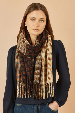 Woman wearing a plaid scarf against a beige background