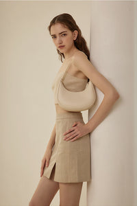 Woman wearing a beige outfit against a plain background with text overlay.