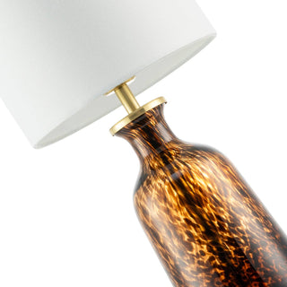 Table lamp with tortoiseshell base and white shade on a white background