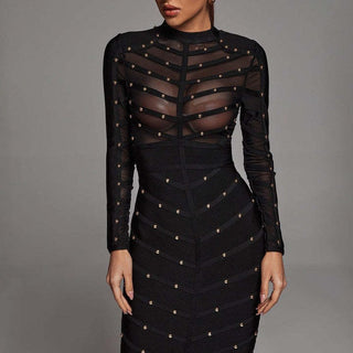 Black dress with sheer panels and gold embellishments on a gray background