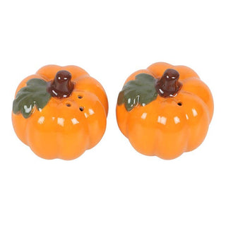 Two pumpkin-shaped salt and pepper shakers on a white background
