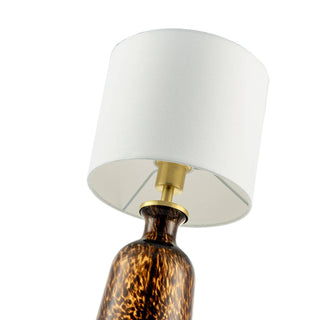 Table lamp with tortoiseshell base and white shade on a white background