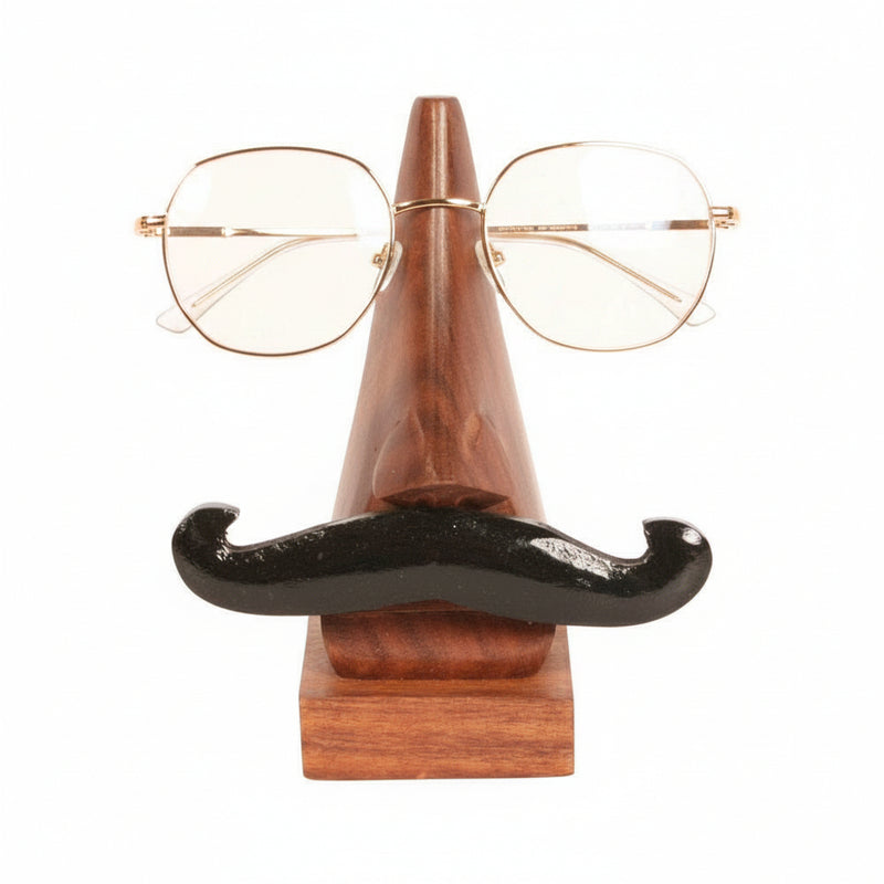 A pair of thin metal-framed eyeglasses displayed on a novelty wooden stand shaped like a nose with a black mustache, against a plain white background.