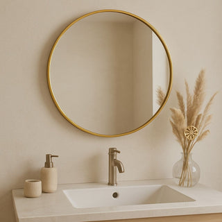 Bathroom vanity with round gold mirror, sink, and decorative elements.