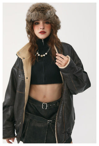 Person wearing a black leather jacket with fur-lined hood and a fur hat on a white background