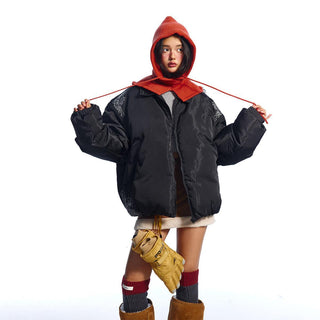 Person wearing a black jacket with a red hood, yellow gloves, and brown boots on a white background